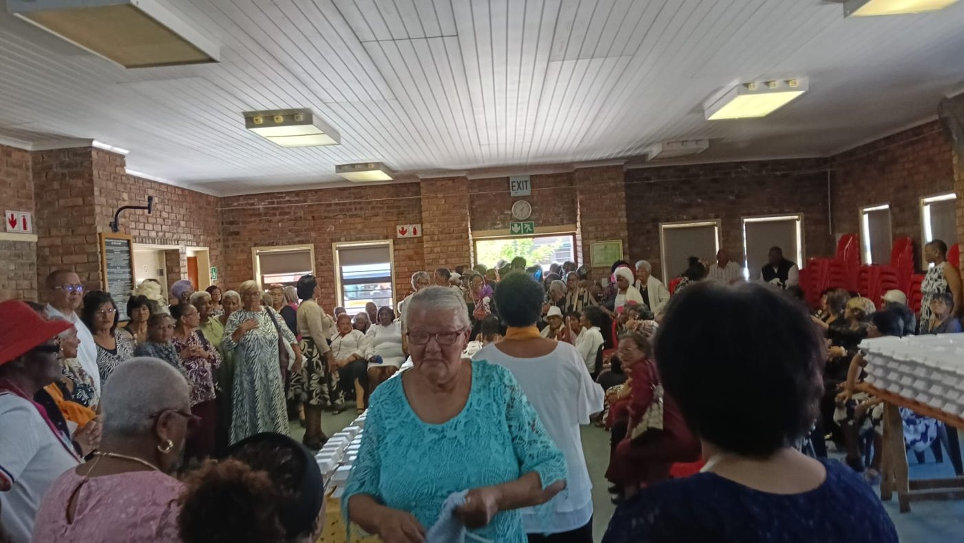 A hall full of senior citizens gathered for a meal