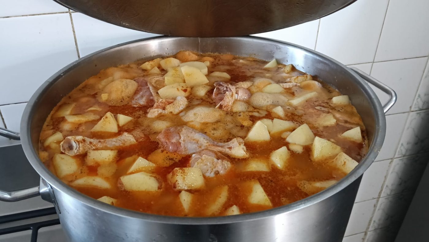 A large pot of chicken and potato stew cooking in a commercial kitchen