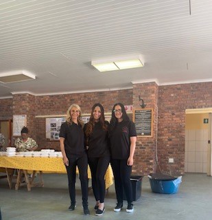 Three team members in black shirts standing together in the hall