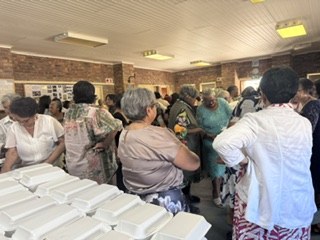 Guests gathering around tables of meal containers