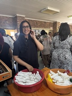 A team member smiling beside bowls of cutlery and napkins