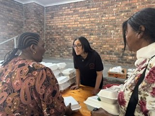 A team member serving meals to guests at the table