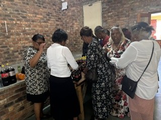 Guests collecting meals and drinks from the serving table