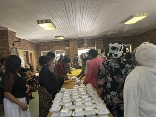 Team members and guests around trays of meals