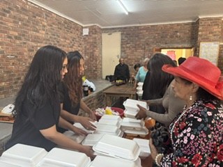 Team members packing meals at a long table